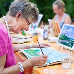 Senior woman smiling while drawing with the group in a nursing home