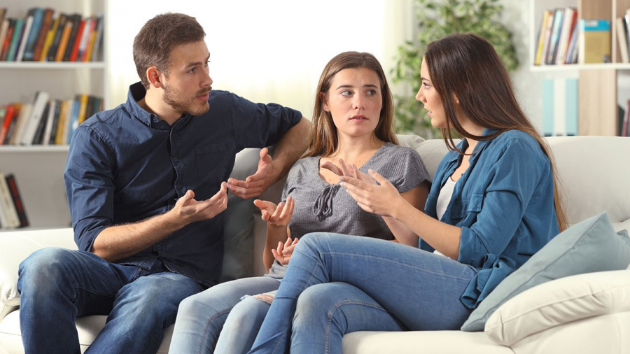 Three family members talking about family assets sitting on a couch at home