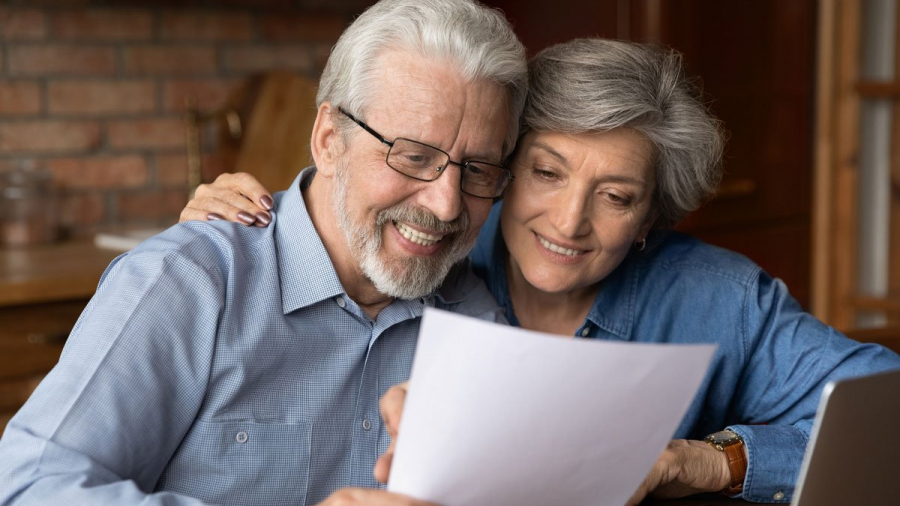 Happy senior couple reading their estate plan.