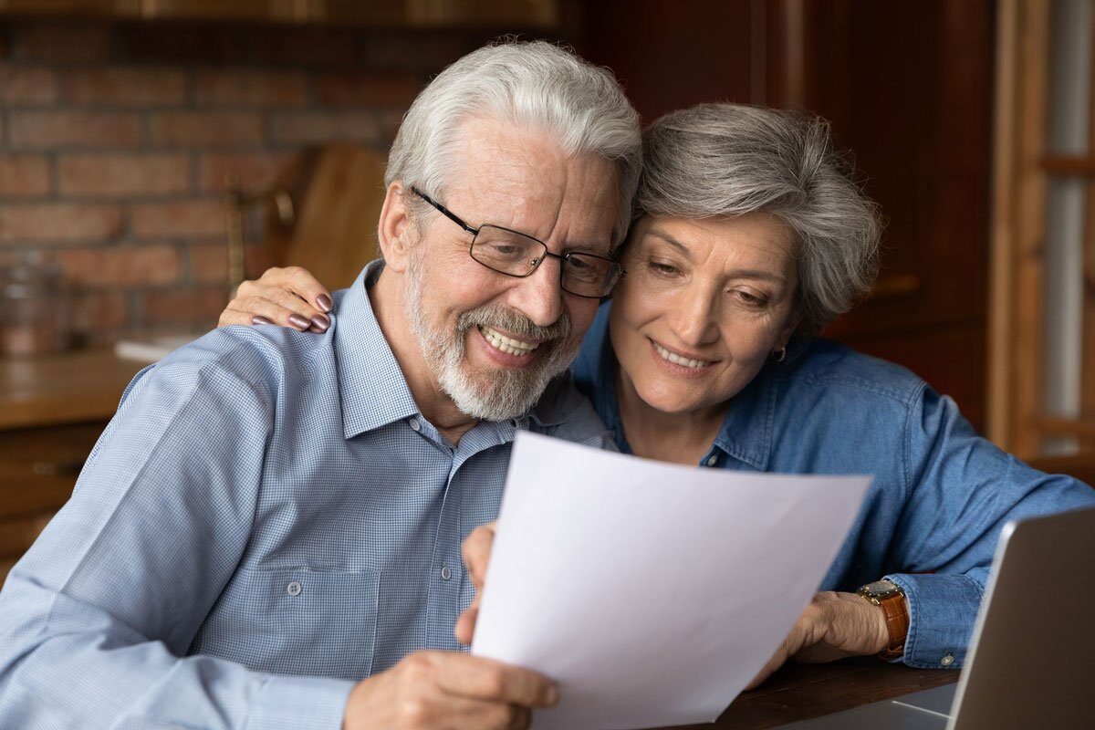 Happy senior couple reading their estate plan.