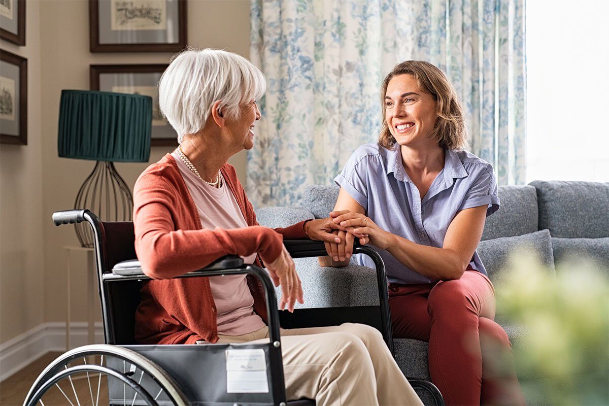Happy adult woman visiting her elderly mother at nursing home