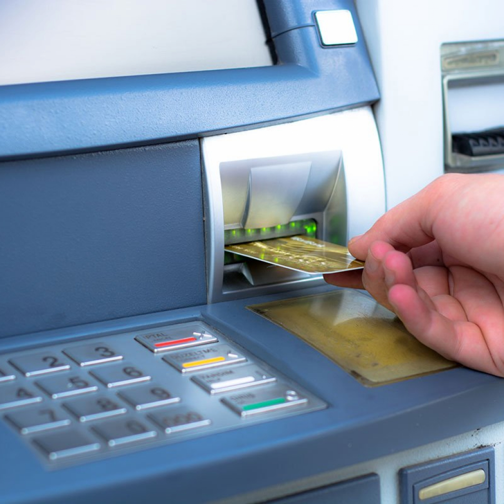 ATM skimming. Hand inserting ATM credit card