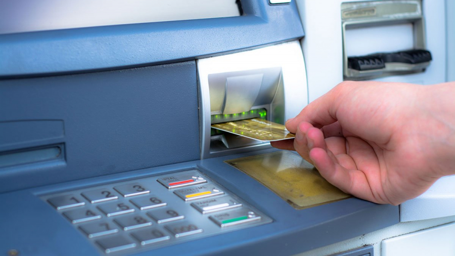 ATM skimming. Hand inserting ATM credit card