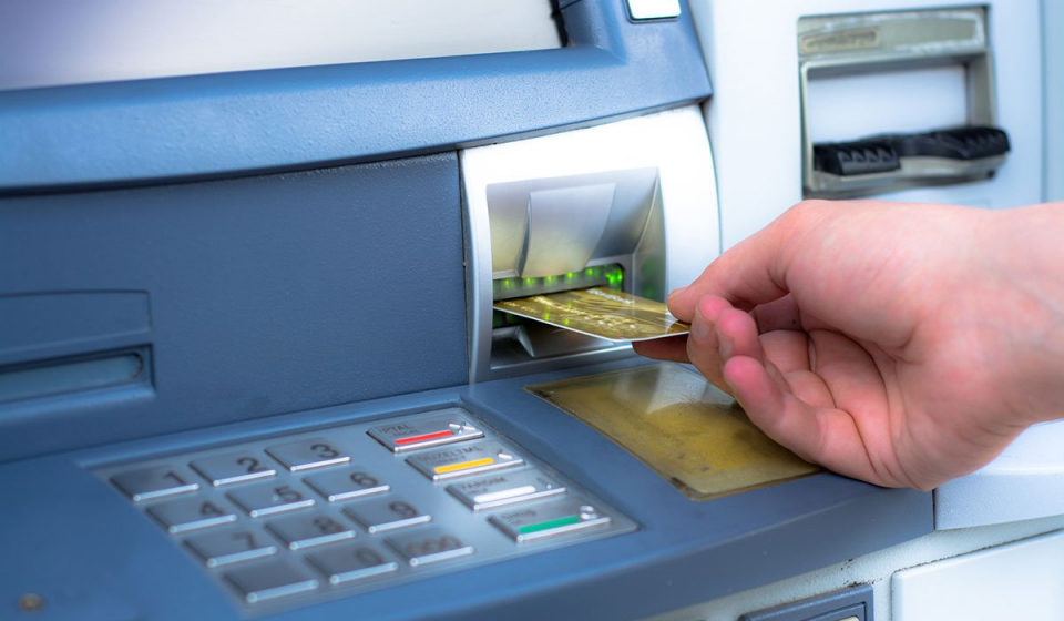 ATM skimming. Hand inserting ATM credit card